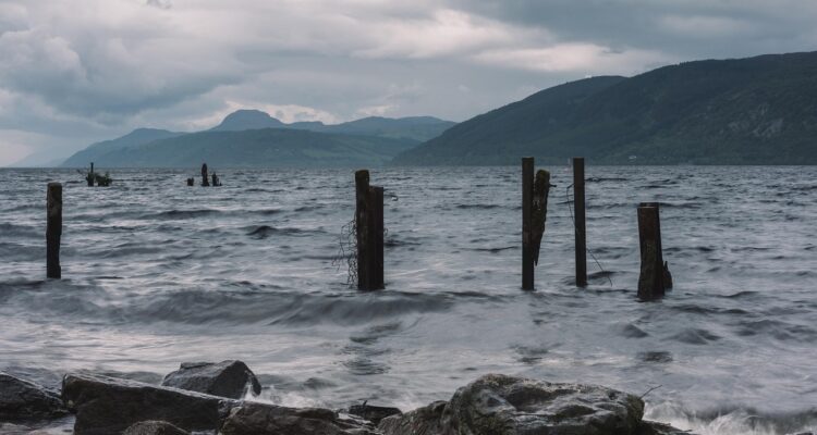 Loch Ness-stranden med gamla stolpar och kullar